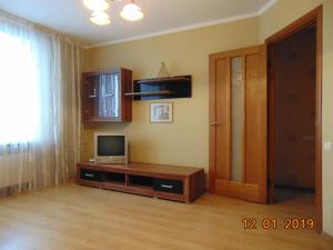 ein Wohnzimmer mit einem TV und einer Tür in der Unterkunft Уютная квартира в районе Медуниверситета in Winnyzja