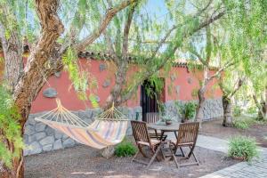eine Hängematte, die von einem Baum vor einem Haus hängt in der Unterkunft La casita del Rincón in Arona