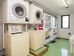 a laundry room with two washing machines on the wall at Bell's Inn Maebashi in Maebashi