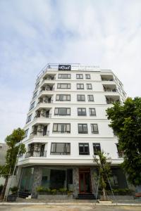 a white building with a sign on top of it at iRest Apartment Vinh Yen in Yen