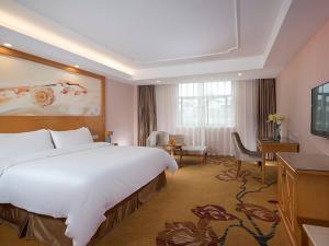 a hotel room with a large bed and a desk at Vienna Hotel (Tianyang Old City High Speed Railway Station) in Baise