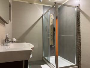 un baño con ducha y lavabo en Pensiunea Colț din Rai, en Tău Bistra 23 fotos más