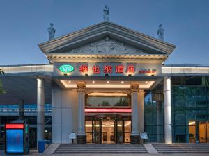 a building with a sign in front of it at Vienna Hotel (East Plaza of WuHan High-Speed Railway Station) in Wuhan