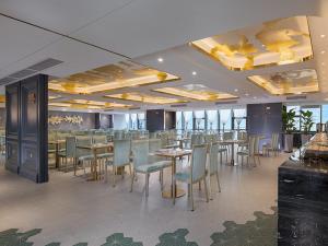 une salle à manger avec des tables et des chaises dans un restaurant dans l'établissement Venus Royal Hotel(Foshan Kuiqi Road Metro Station), à Foshan