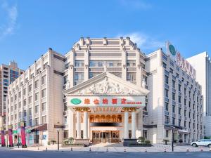 um grande edifício branco com uma placa em frente em Vienna Hotel(Anqing Guangcai Seven-street) em Anqing