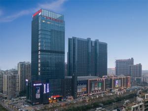 uma cidade com edifícios altos e tráfego na frente em Venus Royal Hotel(Foshan Kuiqi Road Metro Station) em Foshan