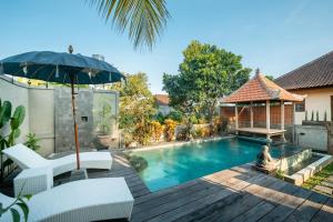 a swimming pool with a chair and an umbrella at Liam Private Villa in Ubud