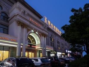 duży budynek z samochodami zaparkowanymi przed nim w obiekcie Vienna Hotel (Shanghai jinshanwei Railway Station City Beach Shop) w mieście Jinshan