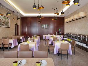 a restaurant with tables and chairs with purple table cloth at Vienna Hotel(Foshan Nanzhuang Ceramic Headquarters ) in Foshan