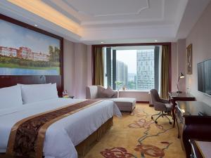 um quarto de hotel com uma cama grande e uma janela grande em Vienna International Hotel (Zhuzhou liyu store) em Zhuzhou