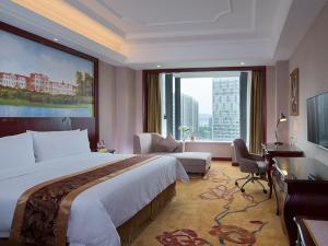 Una habitación de hotel con una cama grande y una ventana grande. en Vienna International Hotel (Zhuzhou liyu store), en Zhuzhou