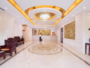 a person standing in a large room with a ceiling at Vienna Hotel(Changshu Sitir Store) in Zhangshu