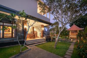 une maison avec un jardin en face dans l'établissement Liam Private Villa, à Ubud