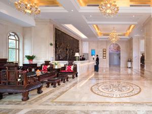 a lobby with benches and chandeliers in a building at Vienna Hotel (Shaoguan Qujiang Shunjing) in Shaoguan