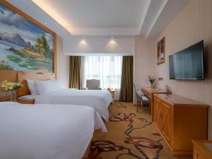 a hotel room with two beds and a flat screen tv at Vienna Hotel(Fuzhou Changle International Airport) in Fuzhou