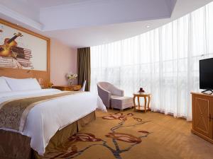 um quarto de hotel com uma cama e uma televisão em Vienna Hotel (Shaoguan Lechang Branch) em Lechang