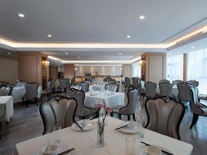 a dining room with tables and chairs in a restaurant at Vienna International Hotel(Jinjiang Jordan Center) in Jinjiang