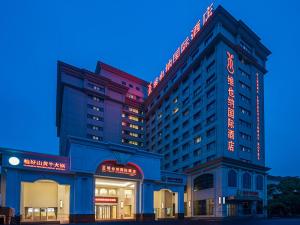 a hotel building with a sign on the side of it at Vienna International Hotel (Changfeng Park Shop, Jinshajiang Road, Shanghai) in Shanghai