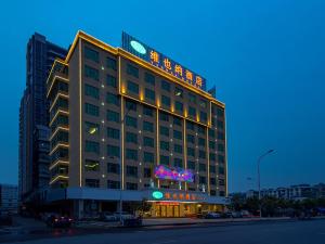 a large building with a sign on top of it at Vienna Hotel (Jieyang Jinxian Dadao Shop) in Jieyang