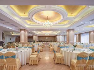 un gran salón de banquetes con mesas y sillas blancas en Vienna Hotel(Nanjin Fuzimiao Muxuyuan Subway Station), en Nanjing