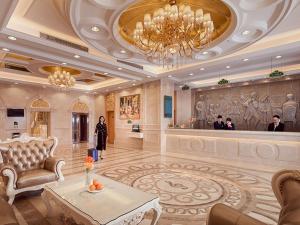a large lobby with a reception area with a chandelier at Vienna International Hotel (Shenzhen Fuyong Convention and Exhibition Center) in Fenghuangwei