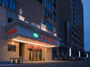 a building with a neon sign in front of it at Vienna Hotel(Fuzhou Changle International Airport) in Fuzhou