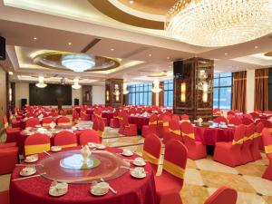 un salón de banquetes con mesas rojas y sillas rojas en Vienna 3 Good Hotel (Wuhu County Bus Station), en Wanzhi