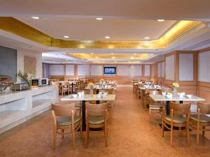 une salle à manger avec des tables et des chaises dans un restaurant dans l'établissement Vienna International Hotel (Shenzhen Fuyong Convention and Exhibition Center), à Fenghuangwei