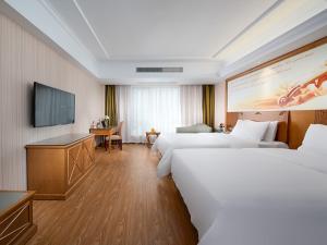 a hotel room with two beds and a flat screen tv at Vienna hotel (huizhou ancient city store, shexian county, huangshan city, anhui province) in She