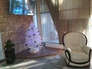 a christmas tree sitting on a table next to a chair at Tourist Hotel in Minsk