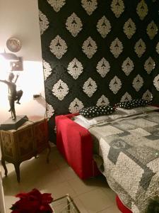 een slaapkamer met een bed en een zwart-witte muur bij Appartamentino in AZ.AGRICOLA - MALPENSA- LAGO MAGGIORE- in Varallo Pombia