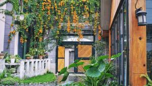 une entrée à un bâtiment avec des fleurs suspendues dans l'établissement Z.Garden, à Dali
