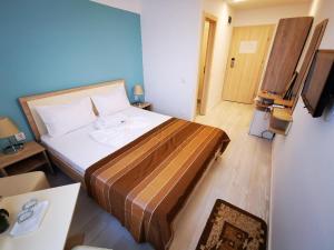 - une chambre avec un lit et une télévision dans l'établissement Hotel Diana, à Eforie Nord