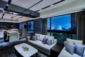 a living room with a couch and a large window at Kung Shang Design Hotel in Kaohsiung