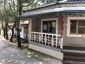 Cette petite maison dispose d'une balustrade blanche et d'une terrasse couverte. dans l'établissement Xiaoye Liu Homestay, à Guoxing