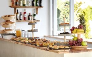 a buffet with different types of food and bottles of wine at Callia Retreat Suites - Adults Only in Fira