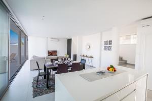 a white kitchen and living room with a table and chairs at Blue Pearl Villas in Protaras