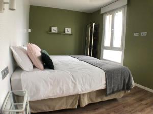 1 dormitorio con cama con almohadas y ventana en Casa Acougo , Sarria, en Sarria