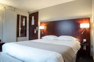 a large white bed in a hotel room with two lamps at Kyriad Saint-Malo Dinard in La Richardais