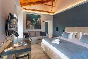 a bedroom with a large bed and a couch at CAMARA SUITES in Andros