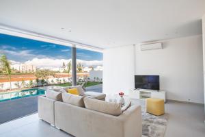 a living room with a couch and a large window at Blue Pearl Villas in Protaras