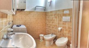 een badkamer met een wastafel, een toilet en een bad bij Arancio in Verbania +8 foto's