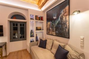 a living room with a couch and a large painting on the wall at CAMARA SUITES in Andros