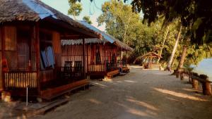 a row of wooden buildings next to the water at Aldejus Homestay in Yennanas Besir