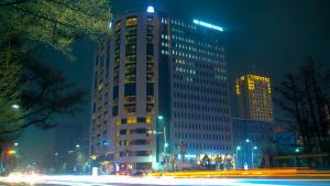 een hoog gebouw wordt 's nachts verlicht bij UB Grand Hotel in Ulaanbaatar