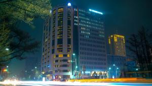 ウランバートルにあるUB Grand Hotelの高い建物は夜にライトアップされる