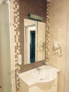 
a bathroom with a mirror and a sink at Garni Hotel Nevski in Belgrade
