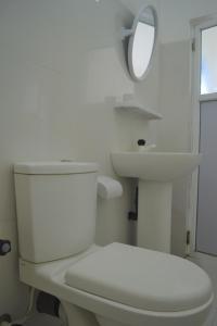 a white bathroom with a toilet and a sink at D'Villa Garden House in Jaffna