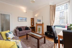 a living room with a couch and a table at Edinburgh Rossie Place Apartment in Edinburgh