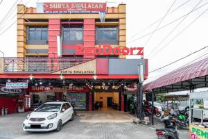 メダンにあるRedDoorz Syariah @ Jalan Setiabudi Medan 3の建物の前に駐車された白い車